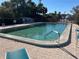 Sparkling community pool with brick pavers, sun loungers, and lush landscaping for relaxing outdoor living at 25188 Marion Ave # F201, Punta Gorda, FL 33950