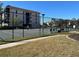Community tennis court behind a black fence offers recreational opportunities and an active lifestyle at 25188 Marion Ave # F201, Punta Gorda, FL 33950