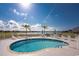 Enjoy the community pool, surrounded by chairs, tables, and serene lake views, perfect for relaxation at 26397 Nadir Rd # 208, Punta Gorda, FL 33983