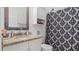 This is a bathroom with a granite countertop vanity and a patterned shower curtain at 2668 Clovelon St, North Port, FL 34291