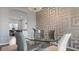Stylish dining area with a glass-top table and contemporary decor, seamlessly connected to the adjacent living space at 2668 Clovelon St, North Port, FL 34291