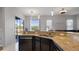 Kitchen with granite countertops, dark cabinets, and stainless steel appliances, seamlessly connecting to the outdoor patio at 2668 Clovelon St, North Port, FL 34291