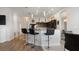 Kitchen island with barstool seating, granite counters, and dark cabinetry, seamlessly connects the kitchen to the living space at 2668 Clovelon St, North Port, FL 34291