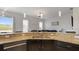 Modern kitchen boasting granite countertops, dark cabinetry, and pendant lighting, complemented by an adjacent living space at 2668 Clovelon St, North Port, FL 34291