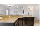 Granite countertop, dark cabinets, and pendant lighting define this stylish kitchen, seamlessly blending with the adjacent living area at 2668 Clovelon St, North Port, FL 34291