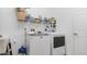 Bright laundry room with modern washer and dryer, sink, and storage shelves at 2668 Clovelon St, North Port, FL 34291