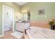 Bathroom showcasing a soaking tub, double vanity, and decorative tile accents at 1020 Caliva St, North Port, FL 34286