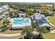 Overhead view of a resort-style community pool with sun loungers and tropical palm trees at 16928 Curry Preserve Dr, Punta Gorda, FL 33982