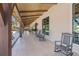 Covered porch with rocking chairs, providing a relaxing outdoor seating area with serene views at 16928 Curry Preserve Dr, Punta Gorda, FL 33982