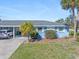Charming light-blue home with manicured lawn, white trim and a modern vehicle parked in the carport at 1956 Wyoming Ave, Englewood, FL 34224