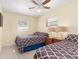 Inviting bedroom featuring two beds, tile floors, neutral walls, and natural light from the windows at 1956 Wyoming Ave, Englewood, FL 34224