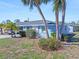 Charming single-story blue home with palm trees and well-maintained landscaping on a sunny day at 1956 Wyoming Ave, Englewood, FL 34224