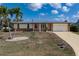 Well-maintained single-story home featuring a durable metal roof, an attached garage, and a welcoming red front door at 520 Boardman Dr, Punta Gorda, FL 33950
