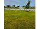 Large backyard featuring a pond with a fountain and well-maintained landscaping with vibrant green grass at 9525 Turtle Grass Cir, Punta Gorda, FL 33950