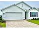 Charming single-story home featuring a paved driveway, two-car garage, and well-maintained landscaping at 9525 Turtle Grass Cir, Punta Gorda, FL 33950
