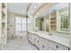 Elegant bathroom featuring double sinks, a large mirror, tub, and decorative wallpaper at 126 Peckham Sw St, Port Charlotte, FL 33952