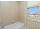 Bright bathroom featuring a bathtub with tile surround and a window at 126 Peckham Sw St, Port Charlotte, FL 33952