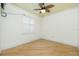 Well-lit bedroom with hardwood floors, ceiling fan, and plantation shutters on the window at 126 Peckham Sw St, Port Charlotte, FL 33952
