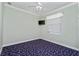 Bedroom features a ceiling fan, window, and blue patterned carpet at 126 Peckham Sw St, Port Charlotte, FL 33952