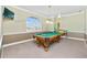 Spacious game room with pool table, carpeted floor, and great window light. Perfect for entertaining or relaxing at 126 Peckham Sw St, Port Charlotte, FL 33952