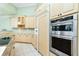 Bright kitchen features custom cabinets, granite counters, stainless appliances, and tiled floors at 126 Peckham Sw St, Port Charlotte, FL 33952