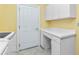 Bright laundry room featuring white cabinetry, a folding counter, tile floors, and a utility sink, providing ample storage space at 126 Peckham Sw St, Port Charlotte, FL 33952