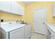 Bright laundry room with white appliances, ample counter space, and storage cabinets at 126 Peckham Sw St, Port Charlotte, FL 33952