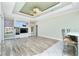Bright living room with tray ceilings, wood floors, built-in entertainment center, and bar seating at 126 Peckham Sw St, Port Charlotte, FL 33952