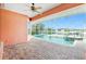 Outdoor living space with a serene pool, spa, screened enclosure, and waterfront views, ideal for relaxation at 126 Peckham Sw St, Port Charlotte, FL 33952