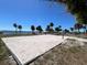 Sandy volleyball court near the water; clear blue skies and palm trees in the background at 126 Peckham Sw St, Port Charlotte, FL 33952