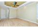 Spacious bedroom with light hardwood floors and a tray ceiling at 126 Peckham Sw St, Port Charlotte, FL 33952