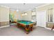 A charming recreation room features a pool table, ceiling fan, and adjacent wet bar at 126 Peckham Sw St, Port Charlotte, FL 33952