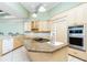 Bright eat-in kitchen features an island, light wood cabinetry, and stainless steel appliances at 126 Peckham Sw St, Port Charlotte, FL 33952