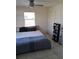 Bright bedroom with neutral walls and tile floor featuring a ceiling fan and storage shelves at 3380 Maple Ter, Port Charlotte, FL 33952