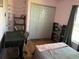 Cozy bedroom with hardwood floors, closet, and shelves for storage and decor at 3380 Maple Ter, Port Charlotte, FL 33952