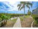 Waterfront backyard featuring a paved path, lush landscaping, and a private boat dock at 5028 San Massimo Dr, Punta Gorda, FL 33950