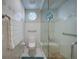Bright white bathroom features a glass enclosed shower with built in seat and octagon window at 5028 San Massimo Dr, Punta Gorda, FL 33950