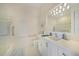 Bright white bathroom with safety grab bars, large vanity and tub/shower combo at 5028 San Massimo Dr, Punta Gorda, FL 33950