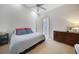 Bright bedroom features vaulted ceiling, ceiling fan, and ensuite bathroom, with dark wood furniture at 5028 San Massimo Dr, Punta Gorda, FL 33950