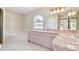 Bright bathroom featuring a garden tub, vanity with dual sinks, and a large arched window at 1426 Natrona Dr, North Port, FL 34286
