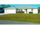 Well-maintained single-story home with a two-car garage, manicured lawn, and arched windows at 1426 Natrona Dr, North Port, FL 34286
