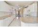 Modern kitchen with white cabinets, stainless steel appliances, stone countertops and tile floors at 1426 Natrona Dr, North Port, FL 34286