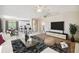 Open-concept living room and dining area with stylish furnishings and bright white tile flooring at 1426 Natrona Dr, North Port, FL 34286
