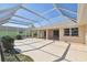 Spacious screened patio with concrete flooring, lush landscaping, and access to the home's interior via sliding glass doors at 1426 Natrona Dr, North Port, FL 34286