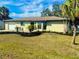 Beautiful single-story home with a well-manicured lawn, lush landscaping, and a paved driveway to a garage at 18938 Ayrshire Cir, Port Charlotte, FL 33948
