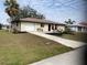 Well-kept single-story home with a manicured lawn and a paved driveway leading to an attached garage at 18938 Ayrshire Cir, Port Charlotte, FL 33948