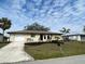 A charming single-story home with a neat yard and a paved driveway leading to an attached garage at 18938 Ayrshire Cir, Port Charlotte, FL 33948