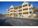 Three-story condominium building with multiple balconies and a neatly paved parking area at 1960 Oregon Trl # 2B, Englewood, FL 34224