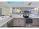 Updated kitchen with stainless steel appliances, tiled backsplash, and convenient overhead lighting at 1960 Oregon Trl # 2B, Englewood, FL 34224