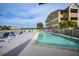 Community pool with lounge chairs and building in the background, under blue skies at 1960 Oregon Trl # 2B, Englewood, FL 34224
